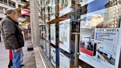 Ciudadanos delante del escaparate de una inmobiliaria en Vigo. 