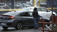 Un taxi circula al lado de un VTC por el que espera una usuaria en A Coruña, en una imagen de archivo.