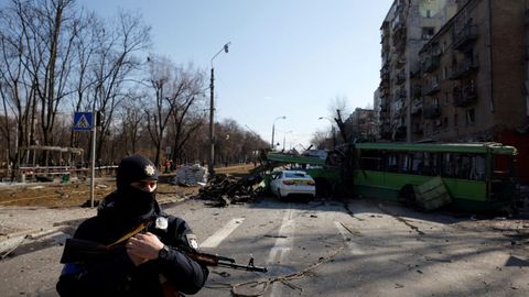 Un agente de polic�a armado se encuentra en el lugar donde un proyectil explot� y da�� un edificio residencial, mientras contin�a el ataque de Rusia a Ucrania, en Kiev