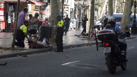 Agentes de la polica municipal de Barcelona atienden a uno de los heridos en el atentado en la Rambla