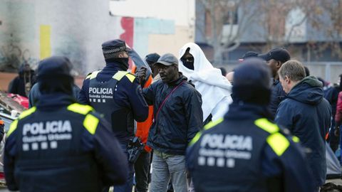  Agentes de la policia local de Badalona (Barcelona) controlan a los inmigrantes desalojados del antiguo instituto B9 de Badalona.