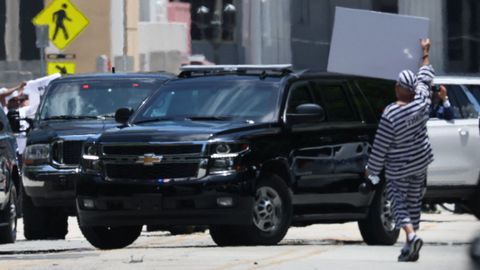 Un hombre intenta para el convoy en el que Trump llegaba al tribunal de Miami.