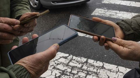 Tres vecinos muestran sus m�viles�en un reciente fallo generalizado en la red m�vil y fija de telefon�a.