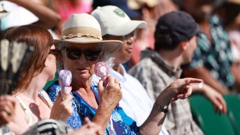 Los asistentes al Campeonato de Wimbledon intentan protegerse del calor en Londres