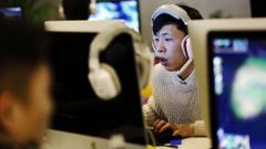 Un joven utiliza un ordenador en un cibercaf� en Pek�n (China)