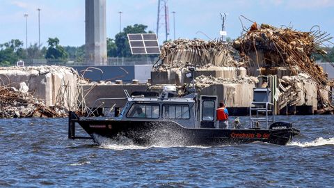 Un barco limpia de escombros el puente de Baltimore.