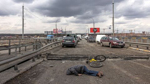 El cuerpo de un yace en la carretera cerca en un puente con coches abandonados en un puente de la ciudad de Irpn, cerca de Kiev