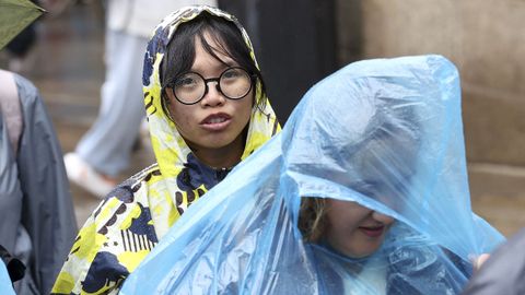 Los visitantes guardaron su turno para acceder al templo bajo la intensa lluvia que cay� en la ma�ana de este martes en Santiago
