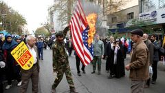 Un iran quema una bandera de EE.UU. en una calle de Tehern