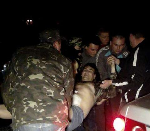 Milicianos prorrusos ayudan a un compañero herido en el asalto al cuartel de la Mariúpol.