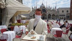 Un camareo del caf� Quadri de Venecia atiende con mascarilla a los clientes