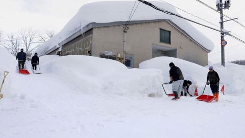 Gente despejando la nieve en un camino en Jap�n