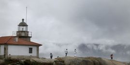 Turistas visitan el faro de Punta Cabalos en A Illa de Arousa en un da nublado