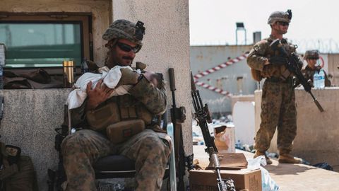 El sargento  Isaiah Campbell sostiene al beb� tras recogerlo del muro del aeropuerto de Kabul. 