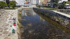 Vecinos mirando el bajo nivel del r&iacute;o Anll&oacute;ns a su paso por Carballo este mi&eacute;rcoles