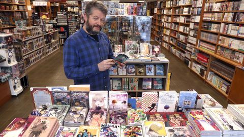 Andrés, de Astora Cómics, con algunos de los títulos de la tienda en Santiago