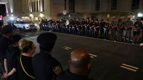 Policías de Nueva York despiden a la ambulancia donde trasladan al agente muerto durante el tiroteo