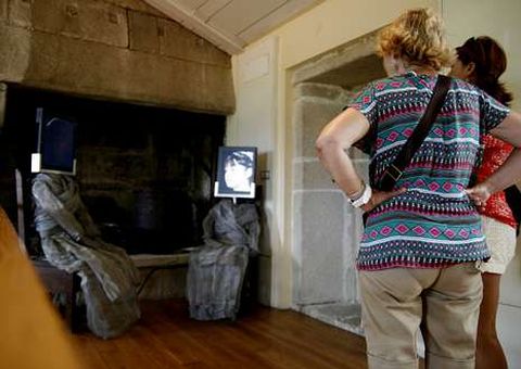 Dos turistas siguen las explicaciones audiovisuales.