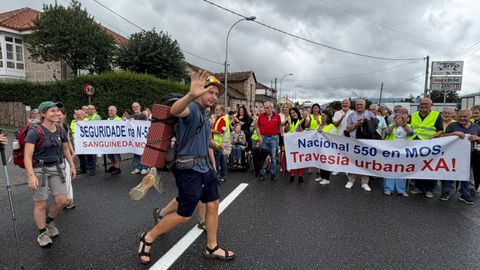 Peregrinos cruzan la carretera delante de los manifestantes