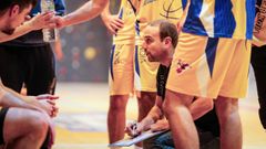 Castro, agachado, dando instrucciones a sus jugadores durante un tiempo muerto.
