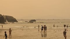 Playa de Os Castros, en Ribadeo, teñida de un color rojizo por el humo de los incendios
