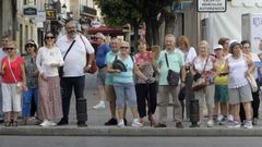 Turistas salmantinos alivian el calor con sus abanicos en una calle de Monforte