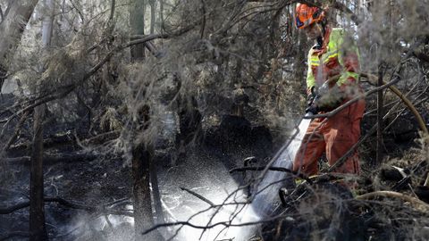 Un bombero trabaja este martes en la extinci�n de un incendio en Soto de Las Regueras