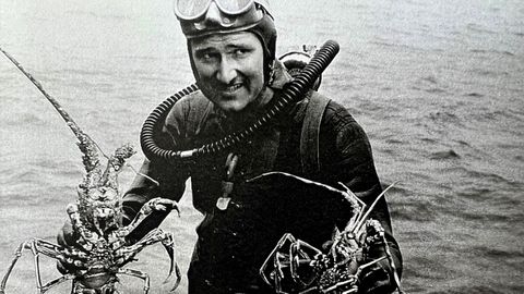 El investigador submarino belga Robert Sténuit posa con dos langostas en la ría de Vigo. En la década de los 50, realizó varias expediciones en esta costa para topar un galeón hundido en la Batalla de Rande.