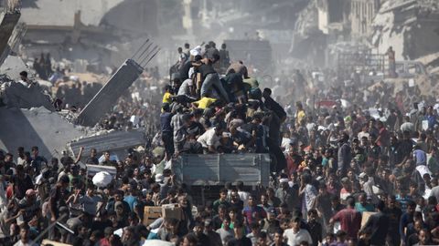Civiles palestinos intentan hacerse con ayuda humanitaria de un camin que lleg a la ciudad de Jan Yunis, en el sur de Gaza, el domingo.