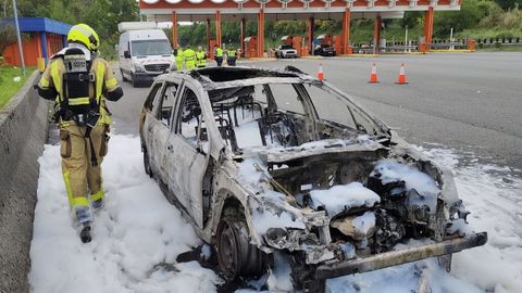 Coche totalmente calcinado en el peaje de la autopista, en Fene