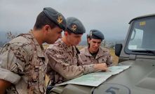 El teniente Huerta (en el centro) examina un mapa de la zona.