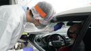 Un trabajador sanitario le realiza un test desde un vehículo a un hombre, en la zona habilitada en el Hospital de Basurto en Bilbao