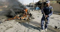 Un polic�a patrulla ante los restos del atentado en Kirkuk.