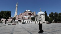 Una mujer vestida con hiyab toma fotografas frente al Museo de Santa Sofa de Estambul