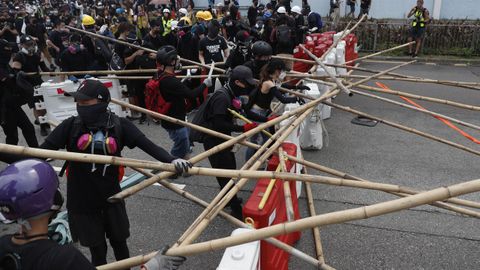Los manifestantes se defienden en kwun Tong con palos y montan barricadas para evitar a los agentes antidisturbios