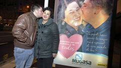 SARA Y SERGIO PAREJA DE ENAMORADOS DE LA PARADA DEL BUS DE LOS CASTROS CON CARTEL PUBLICITARIO DE MUGASA