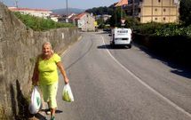 La vecina Mar�a del Carmen M�guez caminando por la carretera con la compra.
