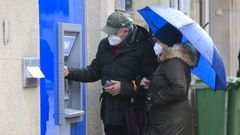 Dos personas mayores en un cajero de la r�a de la Ra��a de Santiago de Compostela