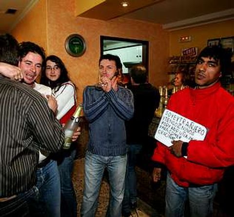 Un inmigrante rumano pide limosna en el bar Arco Iris mientras los premiados celebran el gordo