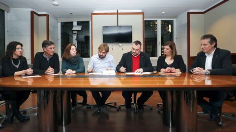 Los secretarios generales de los socialistas asturianos, Adrin Barbn (3d), y de Podemos Asturies, Daniel Ripa (4i), junto a responsables de los dos partidos, durante la firma de un acuerdo presupuestario para 2019.