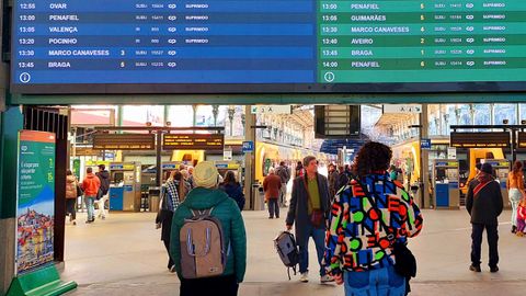 Pasajeros observan los paneles, llenos de cancelaciones, en la estaci�n de S�o Bento, en Oporto
