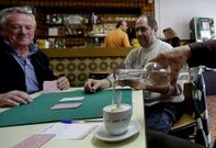 Un cliente de un bar coru��s riega con aguardiente su caf� con leche.