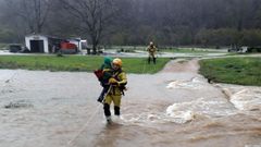 Los bomberos evac�an a una familia aislada por el agua en el concejo de Pilo�a en inmediaciones del paso a nivel de Reboira.