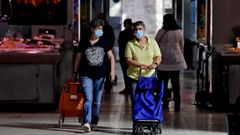 Varias personas protegidas con mascarillas en el Mercado Central de Valencia