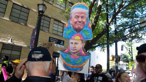 Una persona porta una pancarta de Trump y Putin durante una protesta en Georgia.