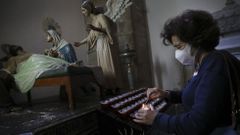 Una feligresa enciende una vela en la iglesia de San Francisco de Santiago