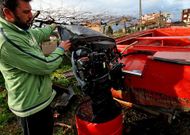Un mariscador vilanov�s muestra el motor da�ado de su embarcaci�n, hundida el s�bado.