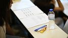 Varios bolígrafos, agua y líquido corrector son algunos de los objetos más repetidos en la mesa. Se puede llevar reloj, pero no inteligente