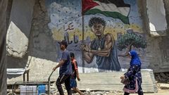 Unos gazt�es pasean frente a un mural dedicado al futbolista Lamine Yamal.