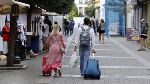 Una pareja abandona este domingo el centro de Ribadeo con sus maletas